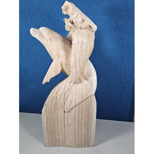 66 - A large hand carved wooden sculpture of a leaping dolphin, well executed, with no visible damage. It... 