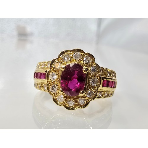 406 - A fine quality 18ct Gold Ruby & Diamond Halo Ring. Claw set with an oval cut natural Ruby weighing 0... 