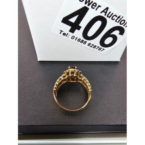 406 - A fine quality 18ct Gold Ruby & Diamond Halo Ring. Claw set with an oval cut natural Ruby weighing 0... 