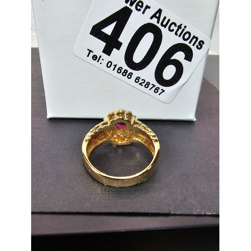 406 - A fine quality 18ct Gold Ruby & Diamond Halo Ring. Claw set with an oval cut natural Ruby weighing 0... 