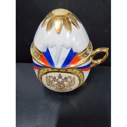 276 - A rare collectable Russian porcelain egg teacup and lid, it is decorated with a Russian flag motif a... 