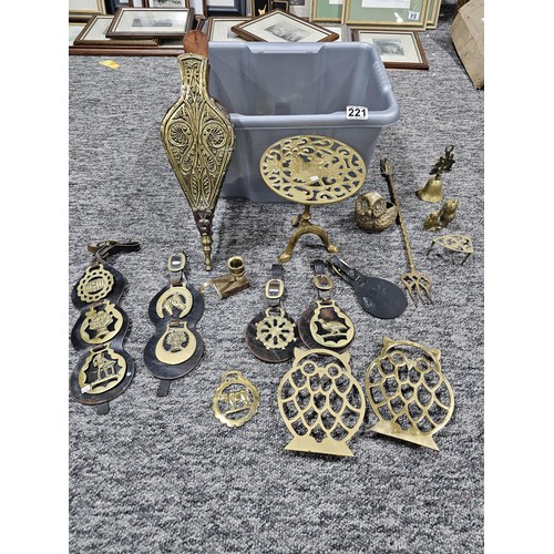 221 - A small crate containing a quantity of assorted brassware to include horse brasses, owl formed trive... 