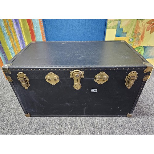 549 - A good quality black travelling trunk with brass clasps in good order, ideal for converting to a cof... 