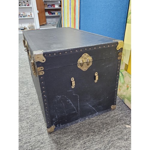 549 - A good quality black travelling trunk with brass clasps in good order, ideal for converting to a cof... 