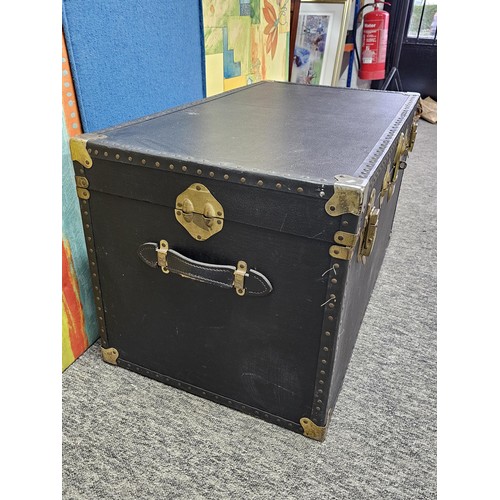 549 - A good quality black travelling trunk with brass clasps in good order, ideal for converting to a cof... 