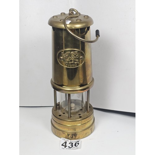 436 - A Welsh brass minors paraffin lamp of cylindrical form applied with a Cymru dragon badge and fully s... 