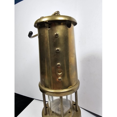 436 - A Welsh brass minors paraffin lamp of cylindrical form applied with a Cymru dragon badge and fully s... 