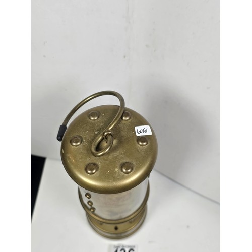 436 - A Welsh brass minors paraffin lamp of cylindrical form applied with a Cymru dragon badge and fully s... 