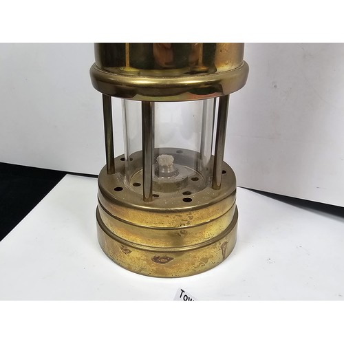 436 - A Welsh brass minors paraffin lamp of cylindrical form applied with a Cymru dragon badge and fully s... 