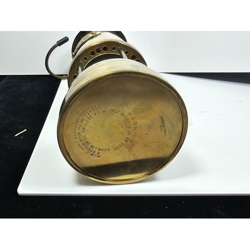436 - A Welsh brass minors paraffin lamp of cylindrical form applied with a Cymru dragon badge and fully s... 