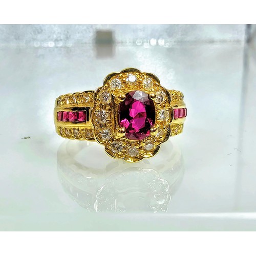 406 - A fine quality 18ct Gold Ruby & Diamond Halo Ring. Claw set with an oval cut natural Ruby weighing 0... 
