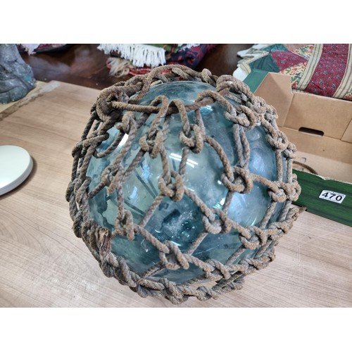 94 - Antique glass hand blown fishing float buoy in good order with original netting surround, the buoy m... 