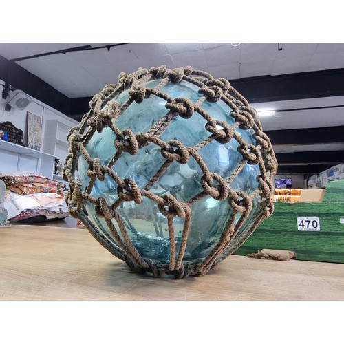 94 - Antique glass hand blown fishing float buoy in good order with original netting surround, the buoy m... 