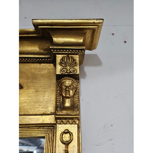 54 - A large ornate gilded triple over mantle bevel edged mirror with a Egyptian frieze to the top, a pha... 