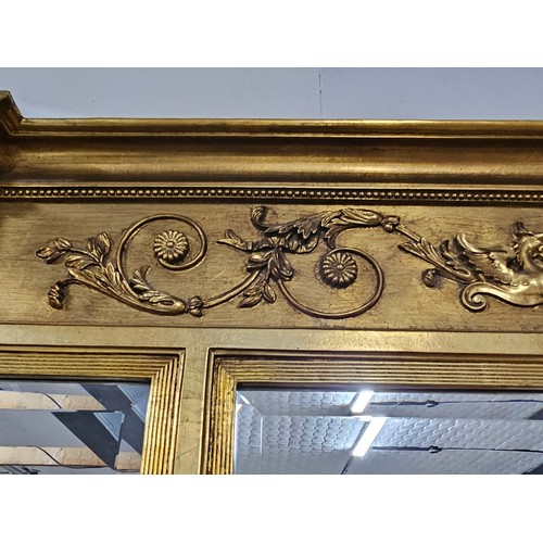 54 - A large ornate gilded triple over mantle bevel edged mirror with a Egyptian frieze to the top, a pha... 