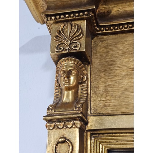 54 - A large ornate gilded triple over mantle bevel edged mirror with a Egyptian frieze to the top, a pha... 