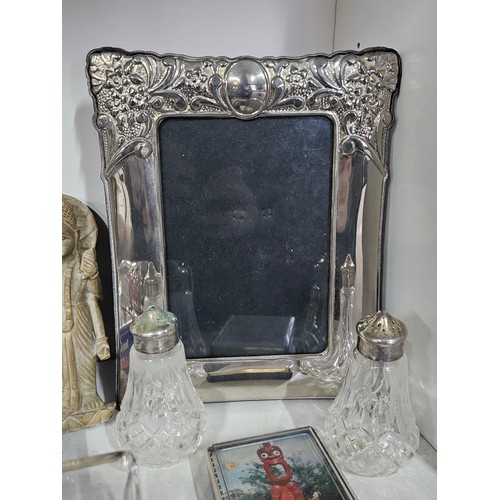 69 - A shelf of collectables to include an art deco style silver plated frame, a collection of engineers ... 