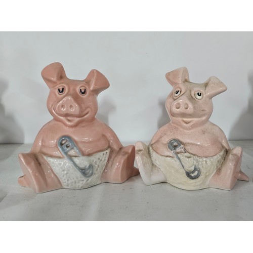 70 - A collection of five Wade pigs to include two babies, mum dad and daughter along with a silver plate... 