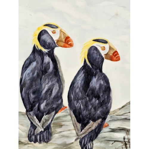 91 - A collection of 3 tiled pictures to include a hand painted framed tile picture of 2 puffins signed t... 