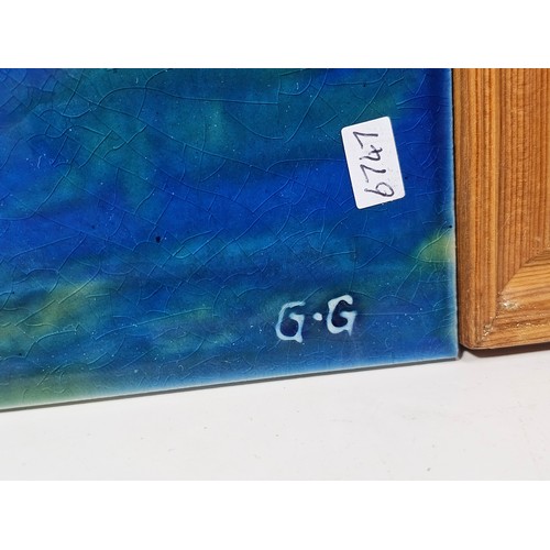91 - A collection of 3 tiled pictures to include a hand painted framed tile picture of 2 puffins signed t... 