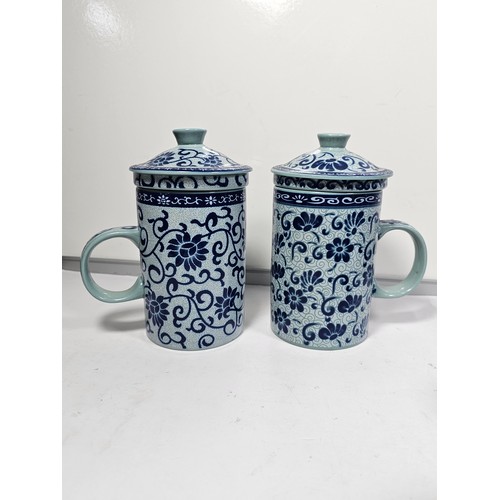 98 - A oriental tea set with a blue floral pattern complete with a teapot with a bamboo handle. Teapot is... 