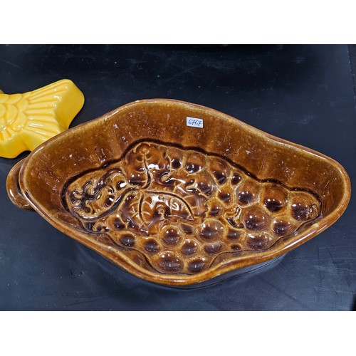 99 - A collection of 5 jelly moulds in earthenware to include 3 fish design moulds, a brown glaze mould a... 