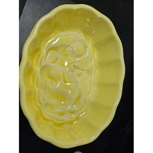 99 - A collection of 5 jelly moulds in earthenware to include 3 fish design moulds, a brown glaze mould a... 