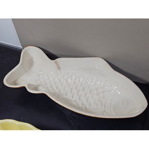 99 - A collection of 5 jelly moulds in earthenware to include 3 fish design moulds, a brown glaze mould a... 