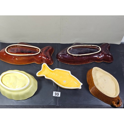 99 - A collection of 5 jelly moulds in earthenware to include 3 fish design moulds, a brown glaze mould a... 