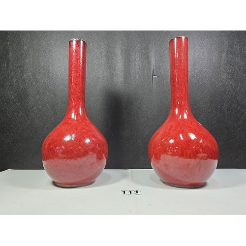 111 - A pair of red bulbous vases both are studio pottery pieces with a mottled design. Both in good order... 