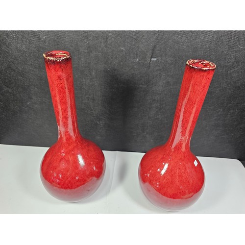 111 - A pair of red bulbous vases both are studio pottery pieces with a mottled design. Both in good order... 