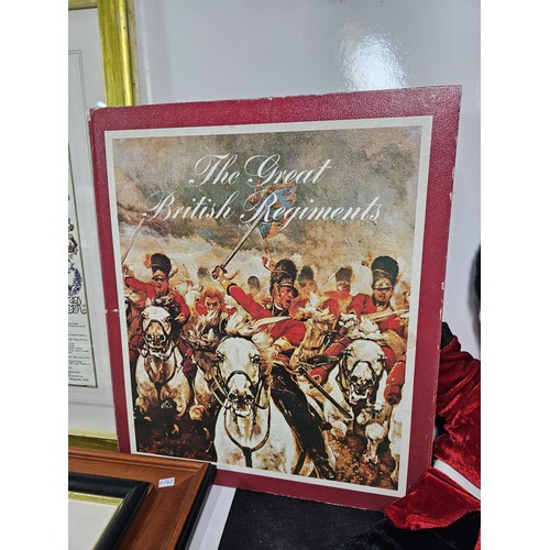 93 - A collection of military and royal related items to include a framed and glazed regimental cap badge... 