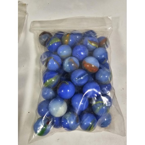 144 - A box containing 8 bags of assorted marbles to include traditional rainbow glass marbles, white marb... 