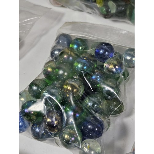 144 - A box containing 8 bags of assorted marbles to include traditional rainbow glass marbles, white marb... 