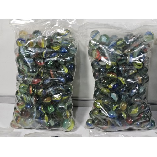 144 - A box containing 8 bags of assorted marbles to include traditional rainbow glass marbles, white marb... 