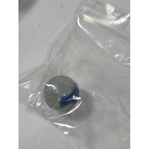 144 - A box containing 8 bags of assorted marbles to include traditional rainbow glass marbles, white marb... 