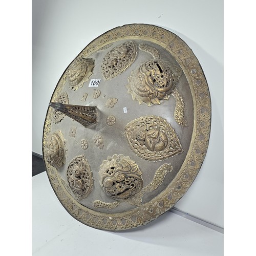 169 - An antique early 20th century Indo-Persian metal Dhal shield with grip bar, the shield is decorated ... 