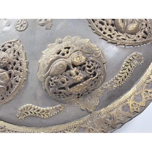 169 - An antique early 20th century Indo-Persian metal Dhal shield with grip bar, the shield is decorated ... 