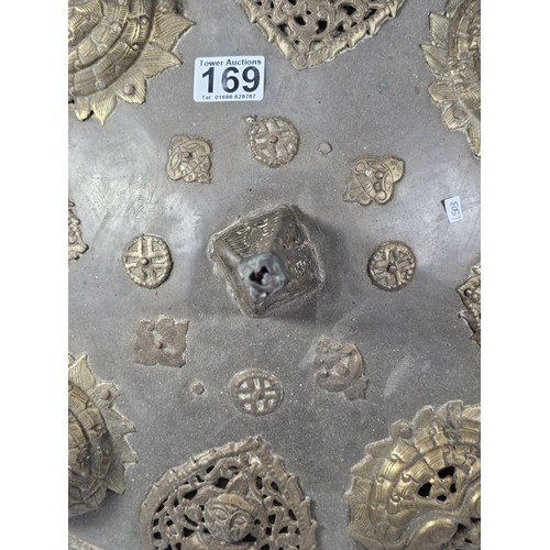 169 - An antique early 20th century Indo-Persian metal Dhal shield with grip bar, the shield is decorated ... 