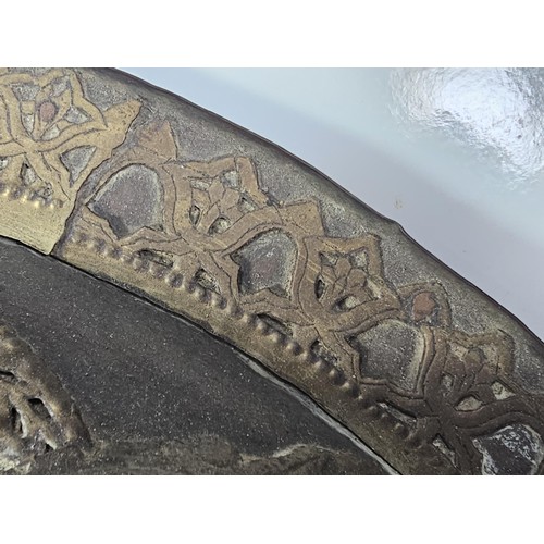 169 - An antique early 20th century Indo-Persian metal Dhal shield with grip bar, the shield is decorated ... 