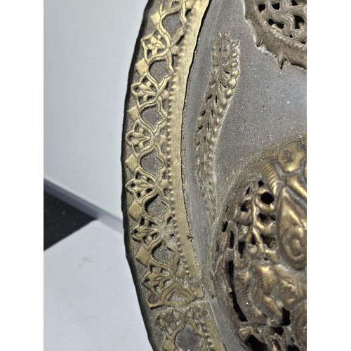 169 - An antique early 20th century Indo-Persian metal Dhal shield with grip bar, the shield is decorated ... 