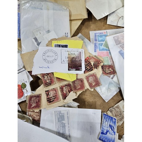 202 - A red hold bag containing a very large quantity of assorted loose stamps to include British stamps, ... 