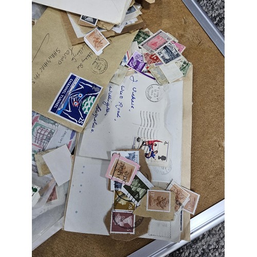 202 - A red hold bag containing a very large quantity of assorted loose stamps to include British stamps, ... 