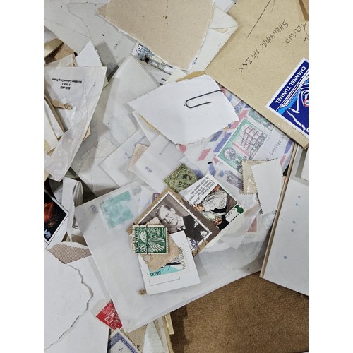 202 - A red hold bag containing a very large quantity of assorted loose stamps to include British stamps, ... 