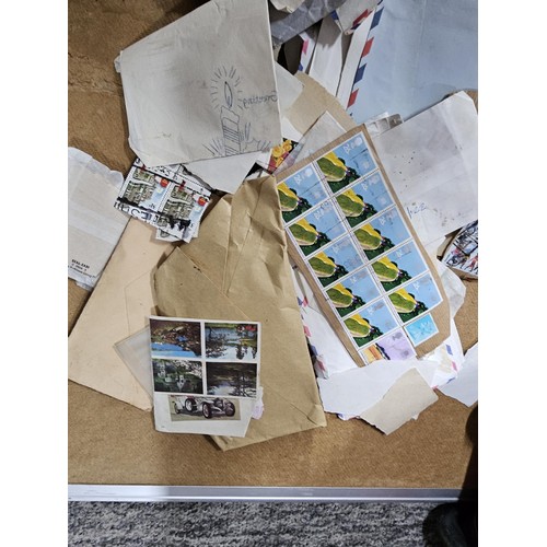 202 - A red hold bag containing a very large quantity of assorted loose stamps to include British stamps, ... 