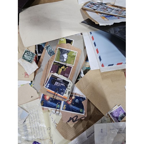 202 - A red hold bag containing a very large quantity of assorted loose stamps to include British stamps, ... 