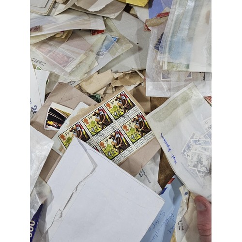202 - A red hold bag containing a very large quantity of assorted loose stamps to include British stamps, ... 
