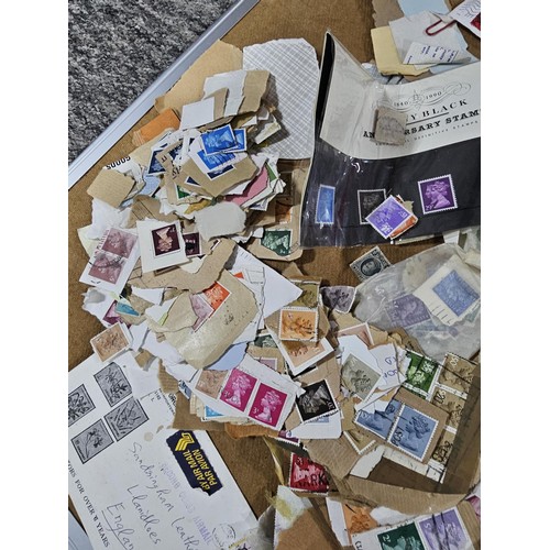 202 - A red hold bag containing a very large quantity of assorted loose stamps to include British stamps, ... 