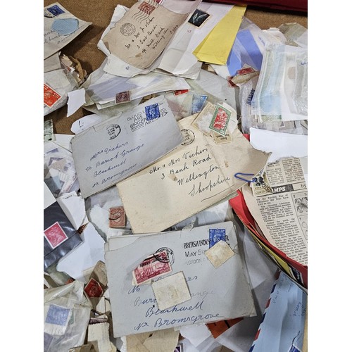202 - A red hold bag containing a very large quantity of assorted loose stamps to include British stamps, ... 