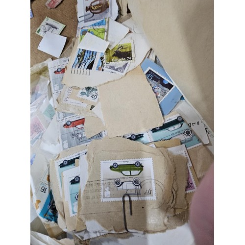 202 - A red hold bag containing a very large quantity of assorted loose stamps to include British stamps, ... 